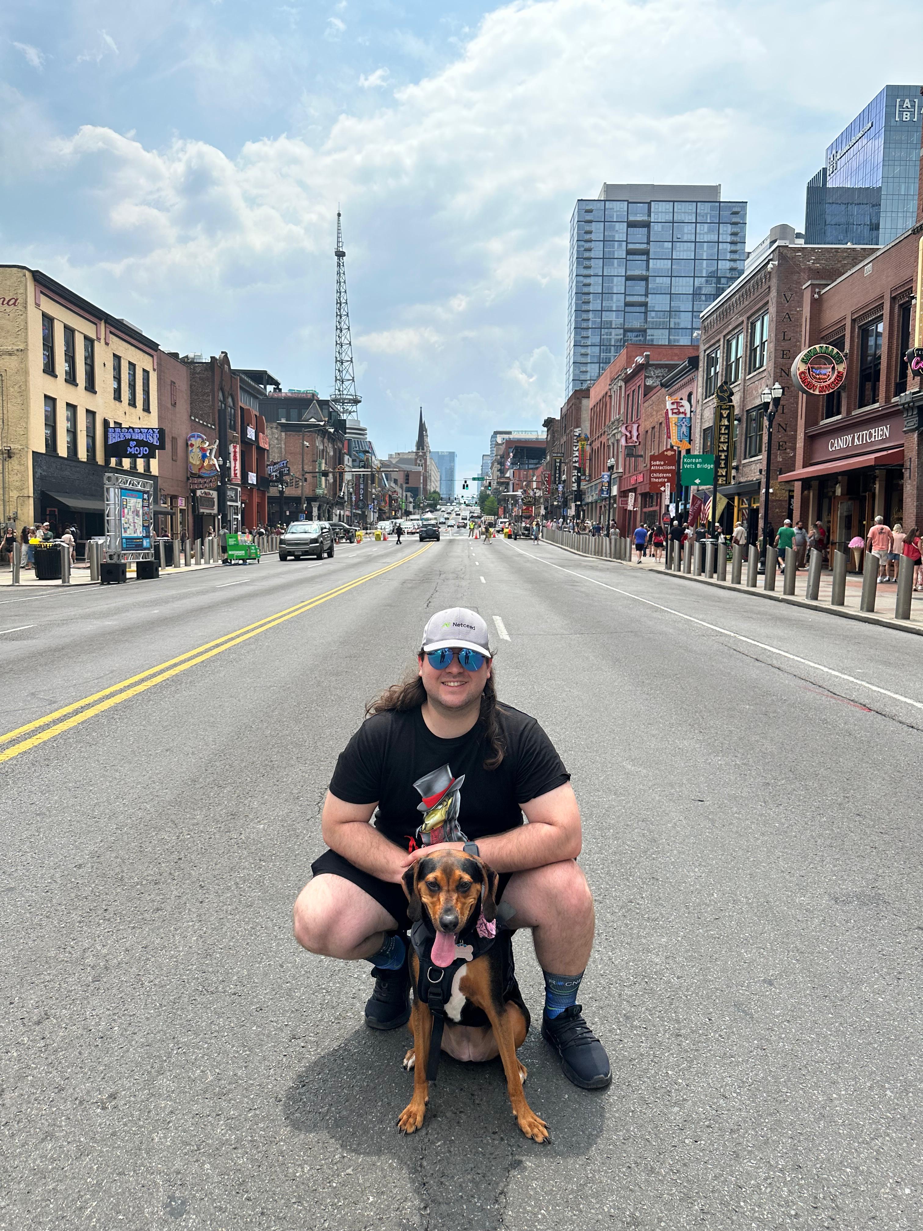 LJ smiling with his dog on a city street